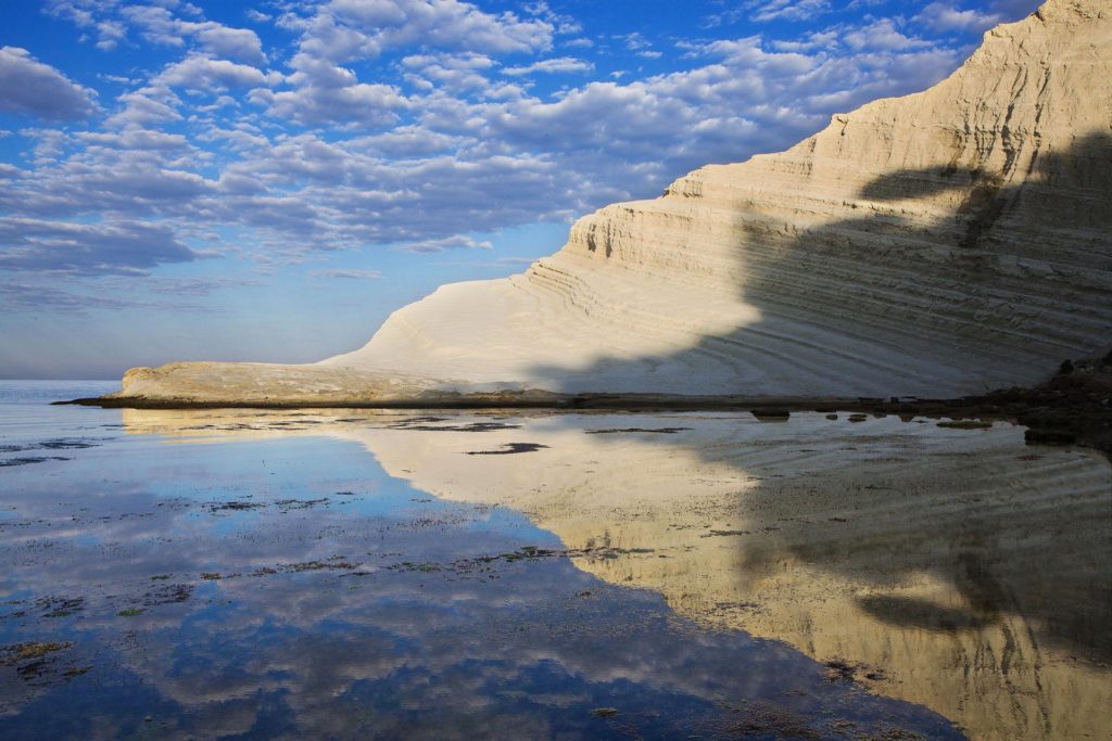 fotografia di paesaggio, mare, terra, scogliera bianca e cielo blu