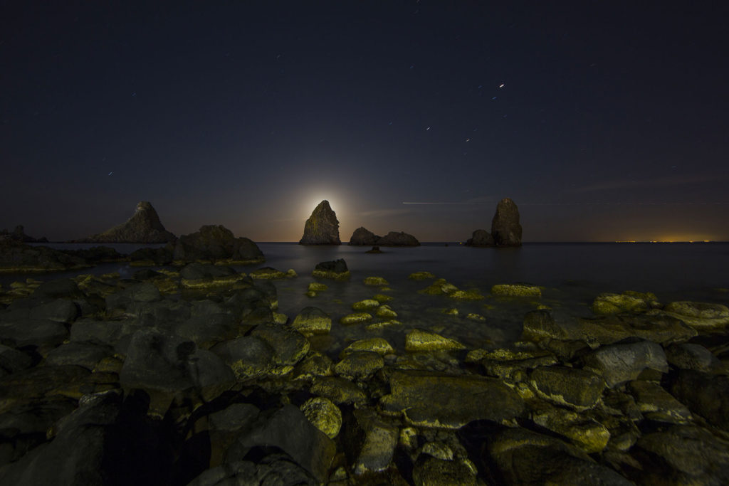 fotografia di paesaggio, mare, notturno, scogli, faraglioni, e luna nascosta