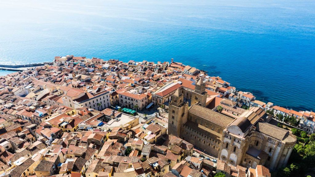 borgo di Cefalù, il duomo e tutti i tetti che lo circondano si affacciano sul mare blu della Sicilia