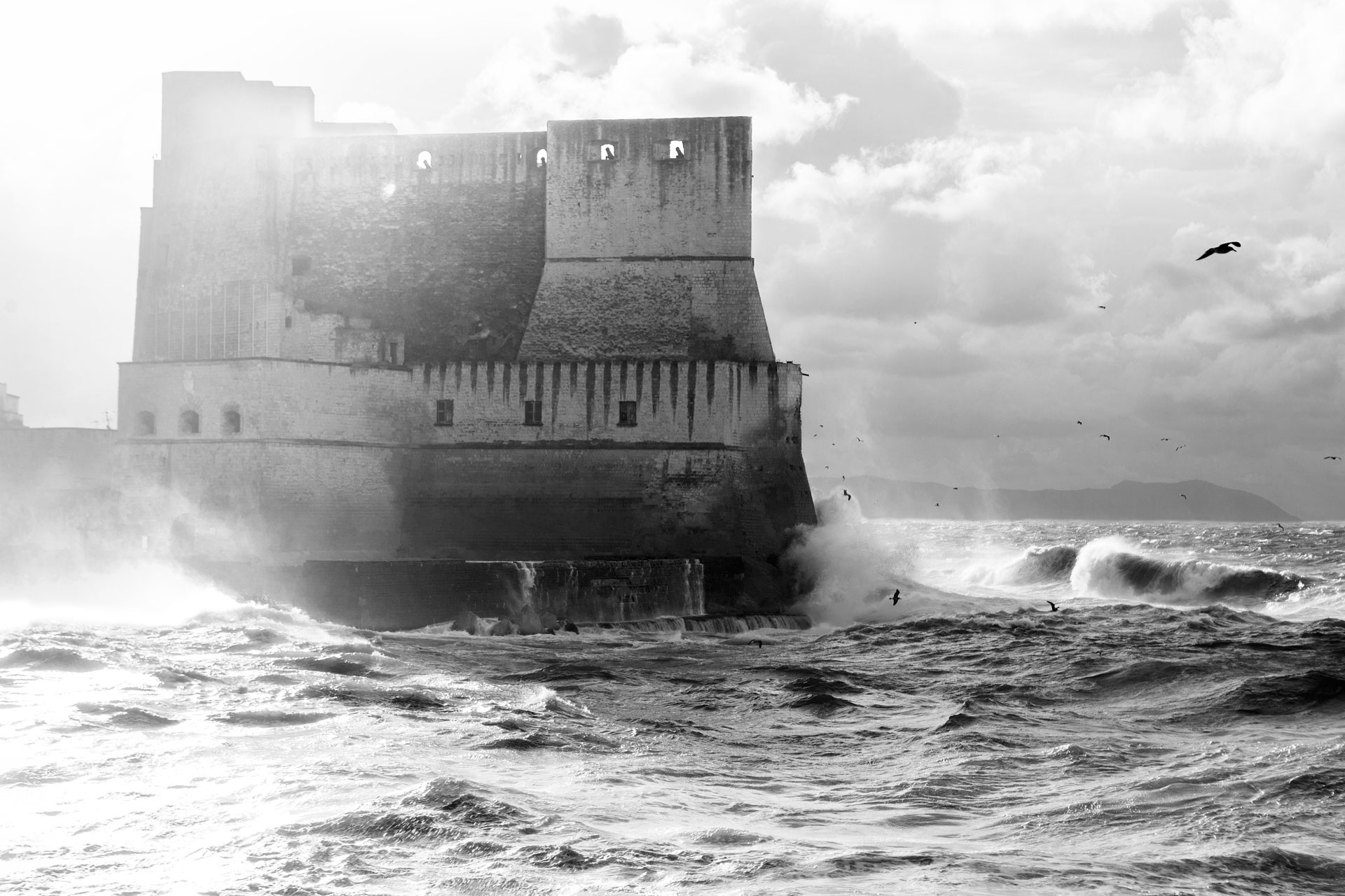 il castello dell'ovo durante una mareggiata, foto in bianco e nero